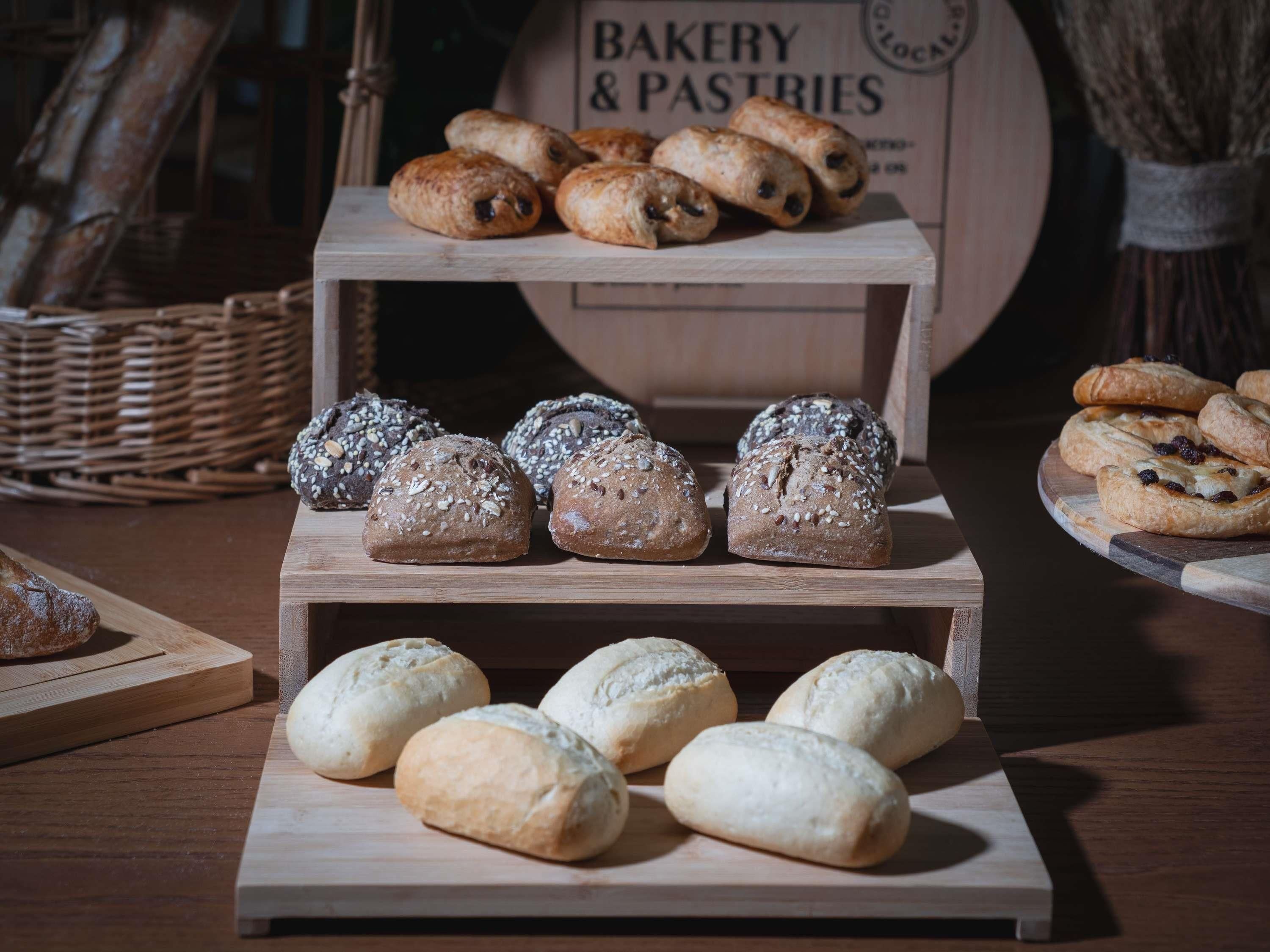 Una vetrina di panetteria con diversi tipi di pane e dolci.