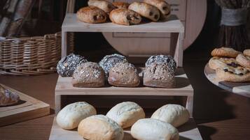 A bakery display with various breads and pastries.