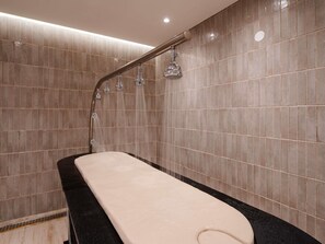 A modern bathroom with a bathtub, a showerhead, and tiled walls. - Mercure Ponta Delgada Azores (Ponta Delgada)
