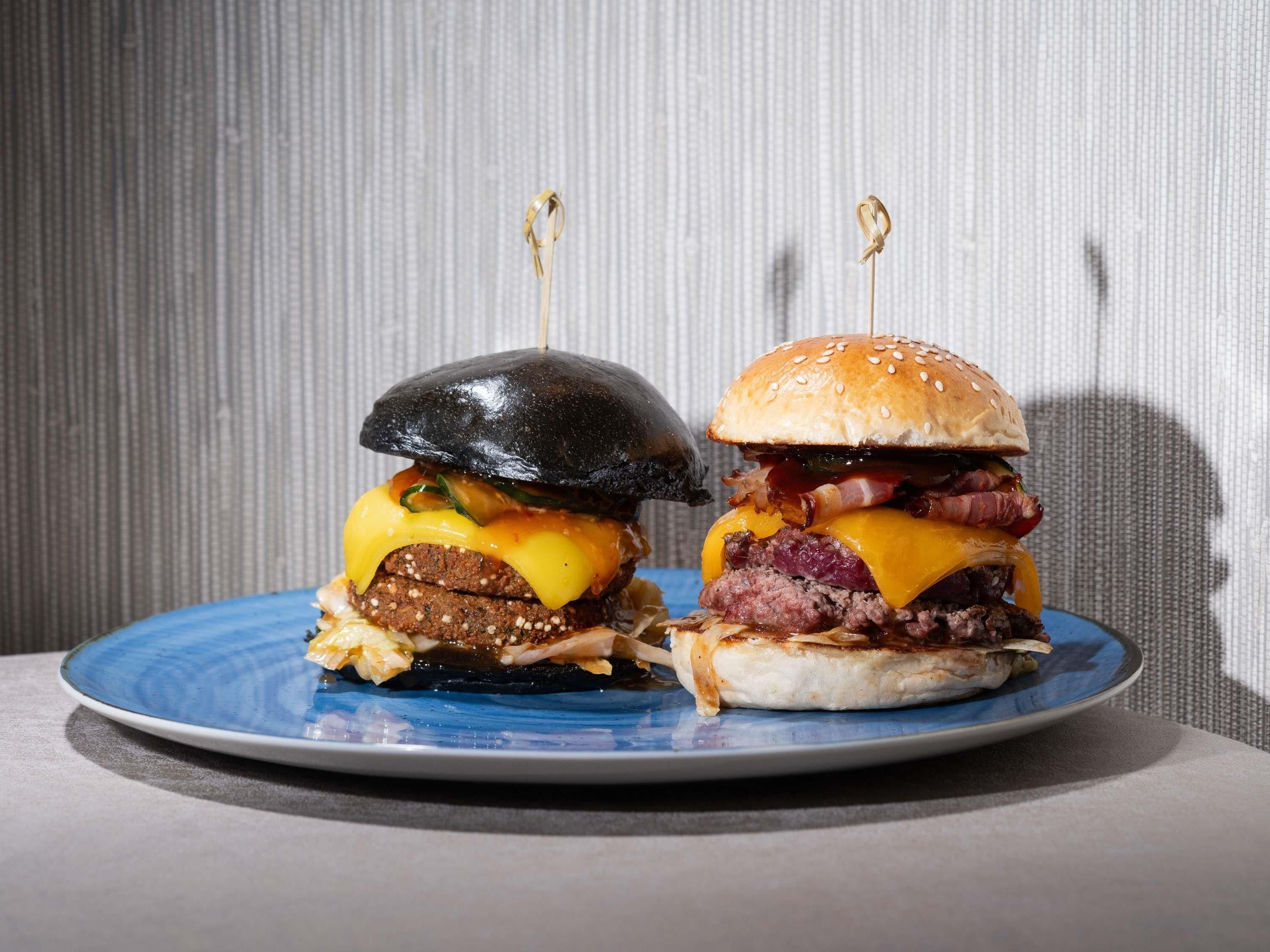 Two burgers on a plate with a textured background.