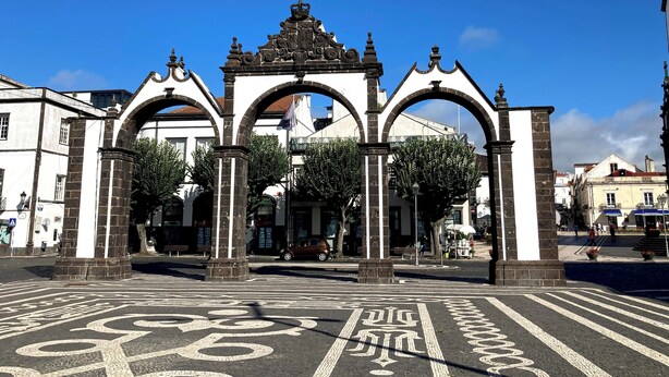 A historic archway with intricate designs and a central emblem, leading to a plaza with a bike lane. - Mercure Ponta Delgada Azores (Ponta Delgada)