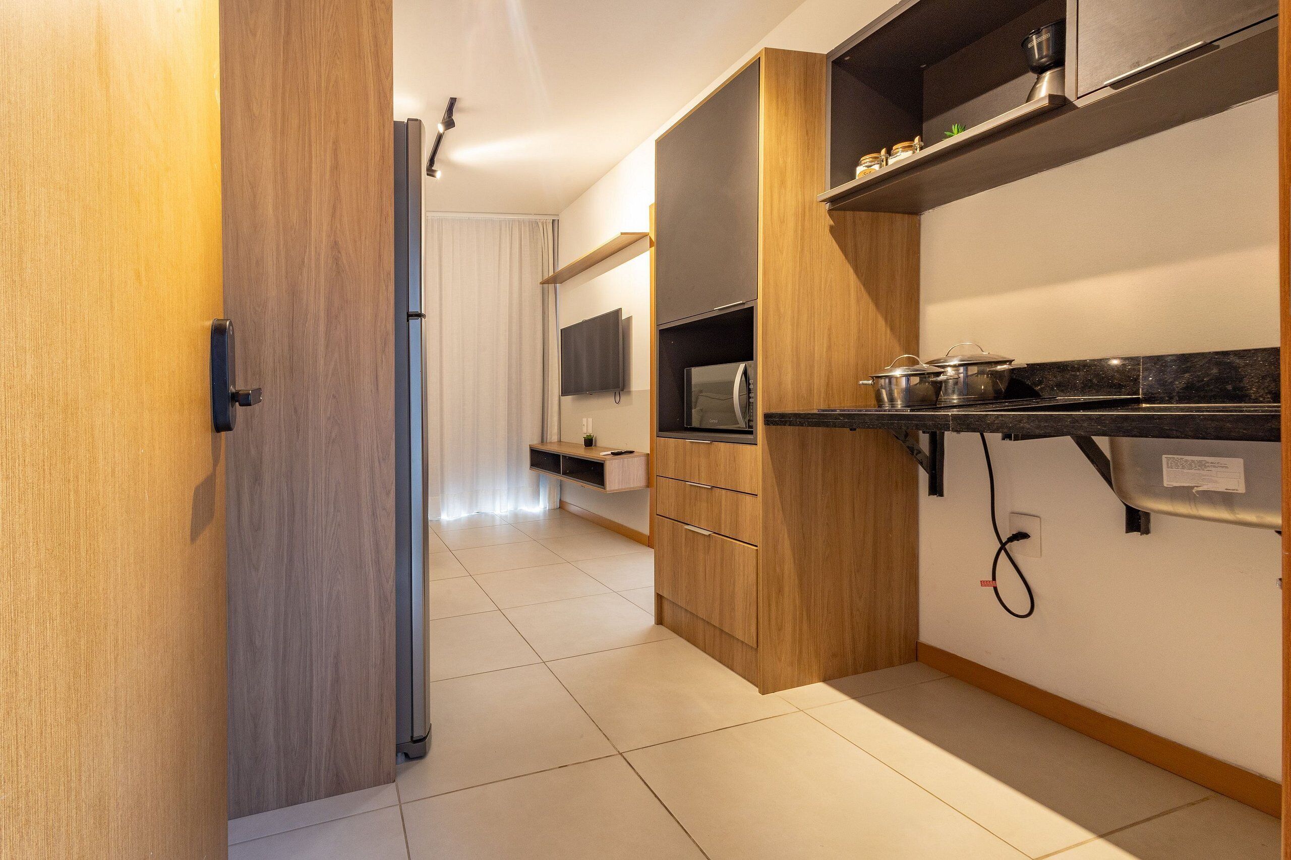 Una cocina moderna con armarios de madera, una encimera y un horno empotrado.