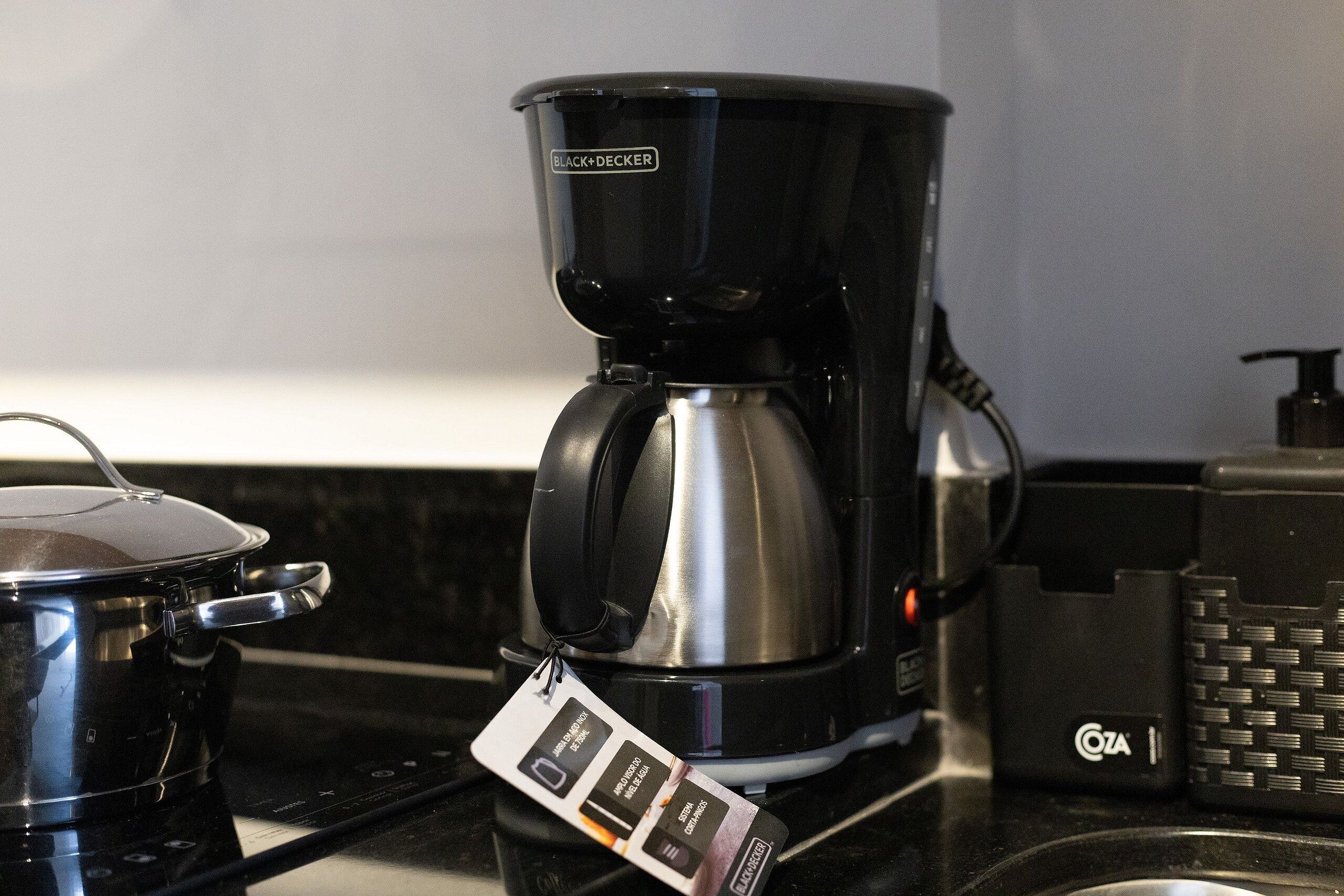Uma cozinha com cafeteira, chaleira e dispensador Cota.