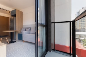 A modern apartment with a balcony, a sofa, a dining table, and a refrigerator. - Porto Privilege Housi by Carpediem (Salvador)