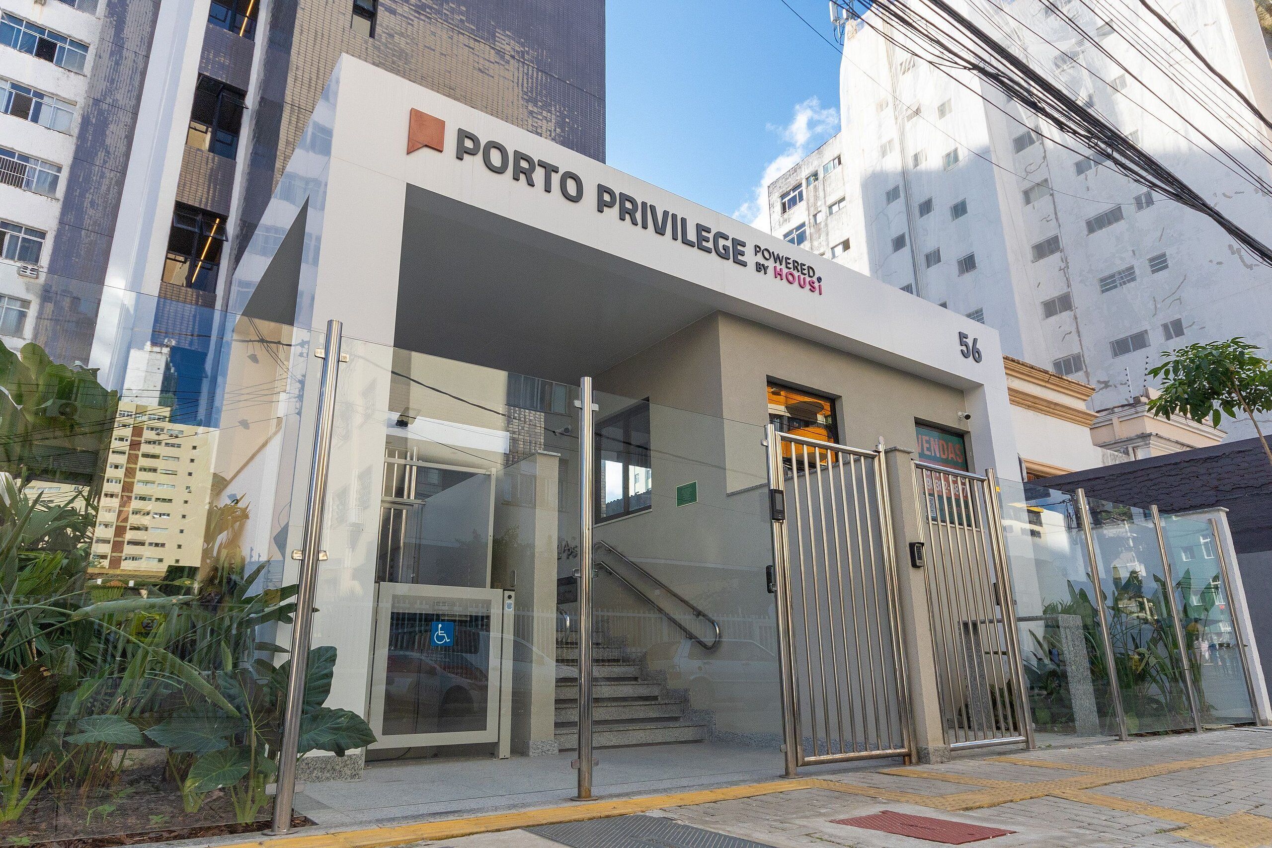 A building with a sign reading 'PORTO PRIVILEGE POWERED BY HOUSES.'