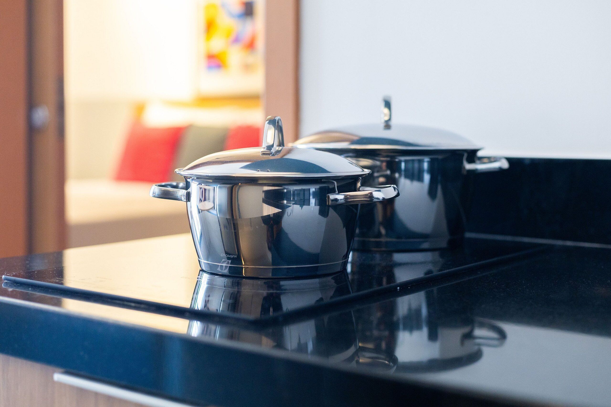 Two stainless steel pots on a black stovetop.