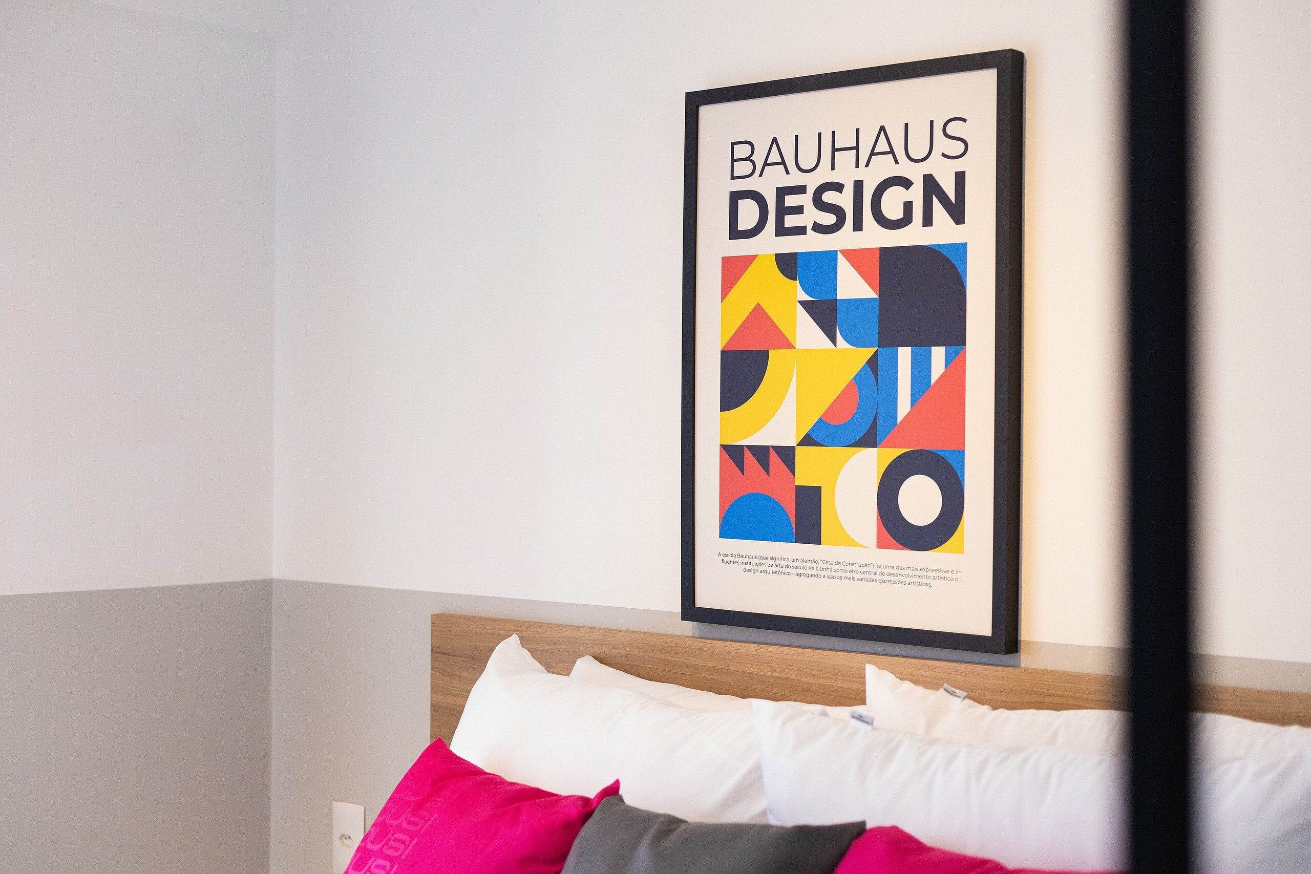 Ein gerahmtes Bauhaus-Design-Poster an einer Hotelzimmerwand.