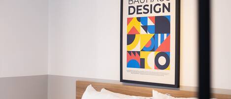 Ein gerahmtes Bauhaus-Design-Poster an einer Hotelzimmerwand.