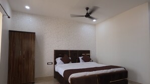 Une chambre à coucher avec un lit, une armoire, un ventilateur de plafond et un tapis rouge.