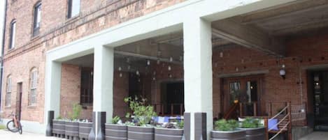 A brick building with a covered entrance and planters along the walkway.
