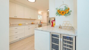 A modern kitchen with white cabinets, a granite countertop, and a built-in oven. - The Beehive New 4 Bedroom Listing Next to CNU (Newport News)