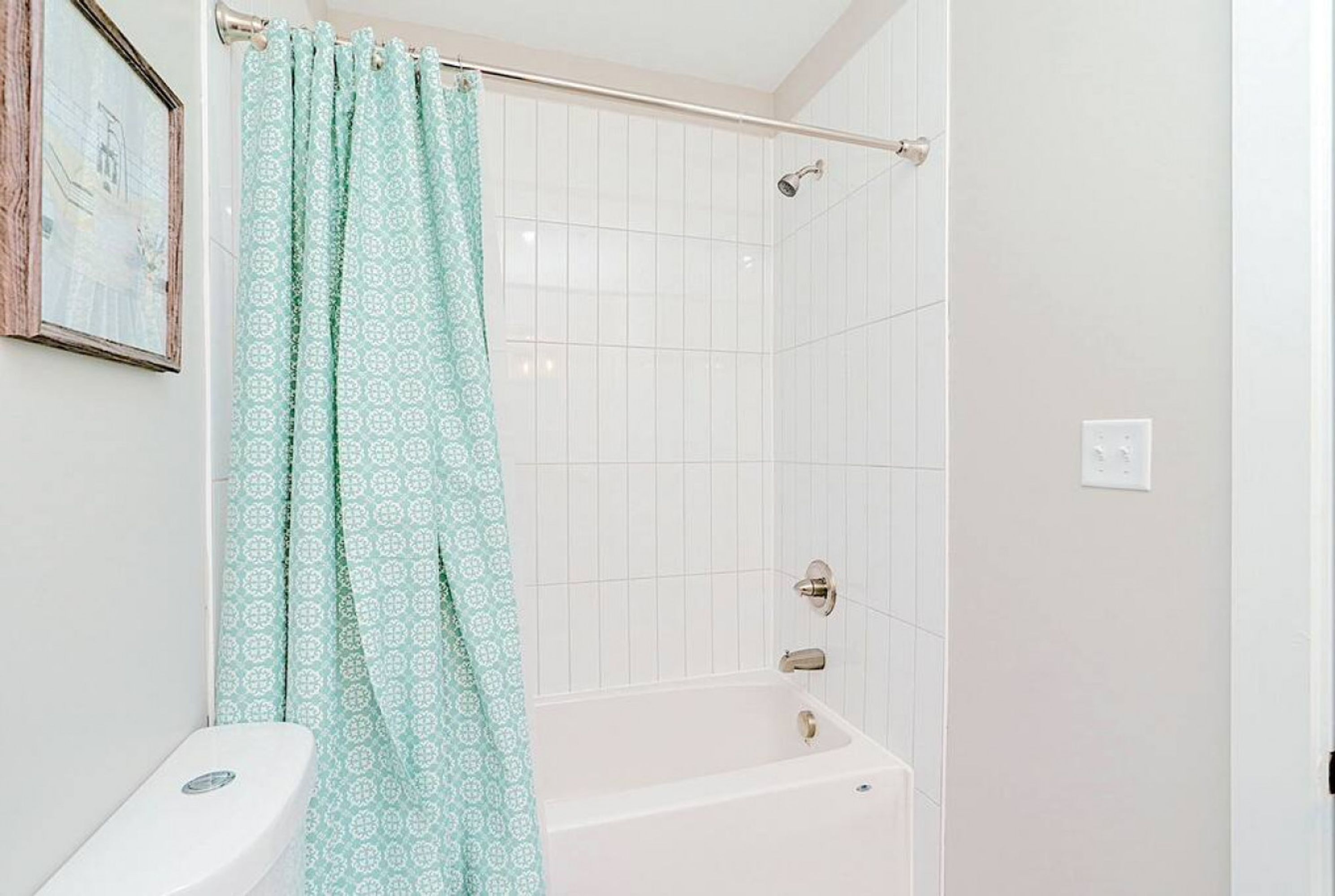 Ein Badezimmer mit Badewanne, Toilette und Duschvorhang.