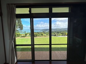 Enjoy a serene view of the lawn, deck, and distant hills from the comfort of this room.
