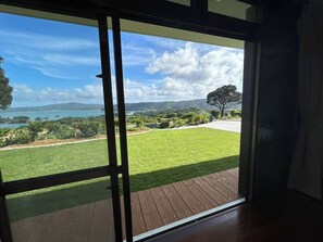 Enjoy a serene view of the well-maintained lawn, deck, and scenic landscape from the comfort of your outdoor space.