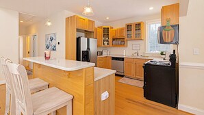 Una cocina moderna con armarios de madera, una isla central y electrodomésticos integrados.