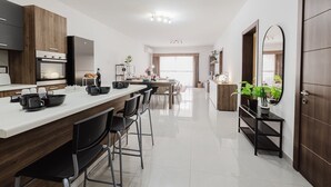Une cuisine moderne dotée d’un îlot central, de tabourets de bar et d’un coin repas offrant une vue agréable.