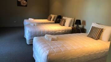 Een hotelkamer met twee bedden, elk voorzien van een kussen en een lamp.