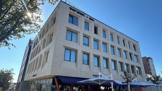 A multi-story hotel with a modern design, featuring a terrace with outdoor seating and umbrellas. - Contactless check-in, functional area of ​​the apartment, workplace (Lviv)