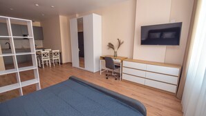 A modern bedroom with a bed, a desk, a chair, a wardrobe, and a TV on the wall. - Contactless check-in, functional area of ​​the apartment, workplace (Lviv)