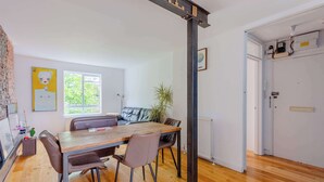 Un coin repas avec une table et des chaises en bois, un canapé et une plante en pot.