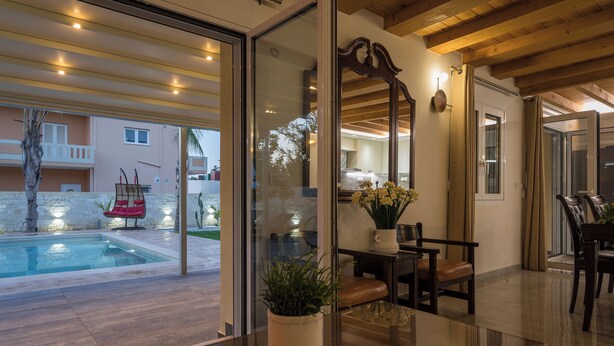 Ein modernes Interieur mit Glastrennwand, Pool und Sitzgelegenheit im Freien.