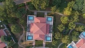 An aerial view of a modern building with a central courtyard, two swimming pools, and a surrounding garden. - Raj Niwas Palace (Dhaulpur)