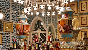 A bar area with a decorative chandelier, a large vase, and various bottles of liquor. - Raj Niwas Palace (Dhaulpur)