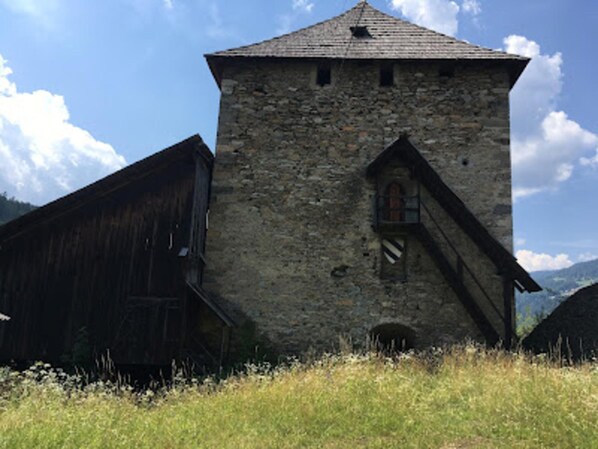 A stone tower with a wooden staircase leading to a window.