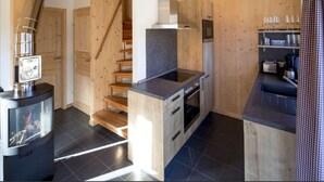 A modern kitchen with wooden walls, a built-in stove, and a small dining area.