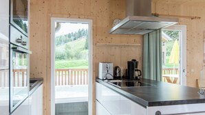 Una cocina moderna con un ventanal grande, horno empotrado y cafetera.