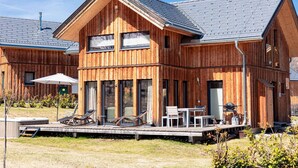 A wooden building with a deck, outdoor seating, and a hot tub. - Superior Chalet With Sauna (Sankt Georgen am Kreischberg)