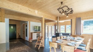A wooden interior with a dining area, a television, and a fireplace. - Superior Chalet With Sauna (Sankt Georgen am Kreischberg)