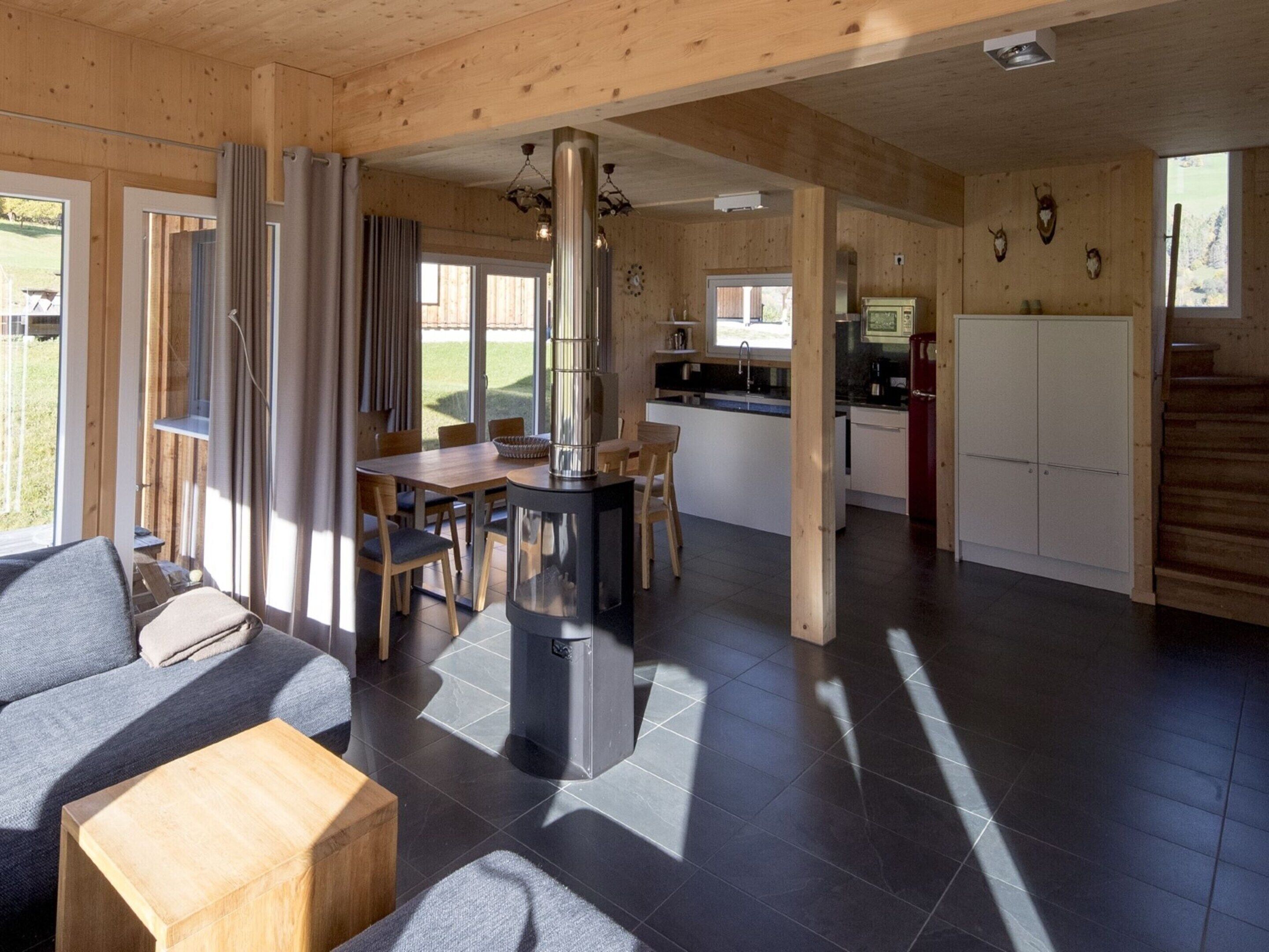 A modern cabin interior with a dining area, kitchen, and living space.