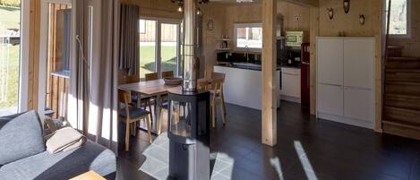 A modern cabin interior with a dining area, kitchen, and living space.