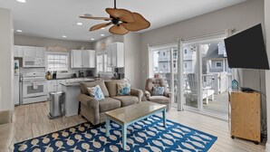 A modern living room with a sofa, coffee table, and a ceiling fan. - Aqua Vista #174 - Private Hot Tub, Community Pool, Dog Friendly! (North Topsail Beach)