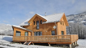 A wooden cabin with a balcony, set against a snowy mountainous backdrop. - Majestic Chalet With Sauna (Sankt Georgen am Kreischberg)