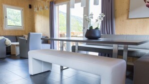 A modern interior with a bench, a dining table, and a view of the outdoors. - Majestic Chalet With Sauna (Sankt Georgen am Kreischberg)