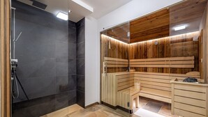 A modern bathroom with a glass shower enclosure, a wooden sauna, and a marble-tiled floor. - Attractive Chalet on the Ski-slopes (Stadl-Predlitz)