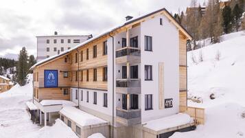 A modern multi-story building with a sign reading "Alps Resorts" and a number "410".