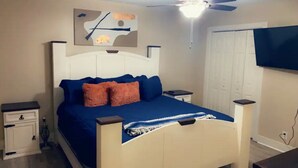 A bedroom with a bed, nightstands, a ceiling fan, a TV, and a door. - Treasure Bay 3-bedroom house with WiFi, fitness room in Monroe  (Monroe)