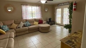 A living room with a beige sectional sofa, a small table, and a ceiling fan. - Treasure Bay 3-bedroom house with WiFi, fitness room in Monroe  (Monroe)