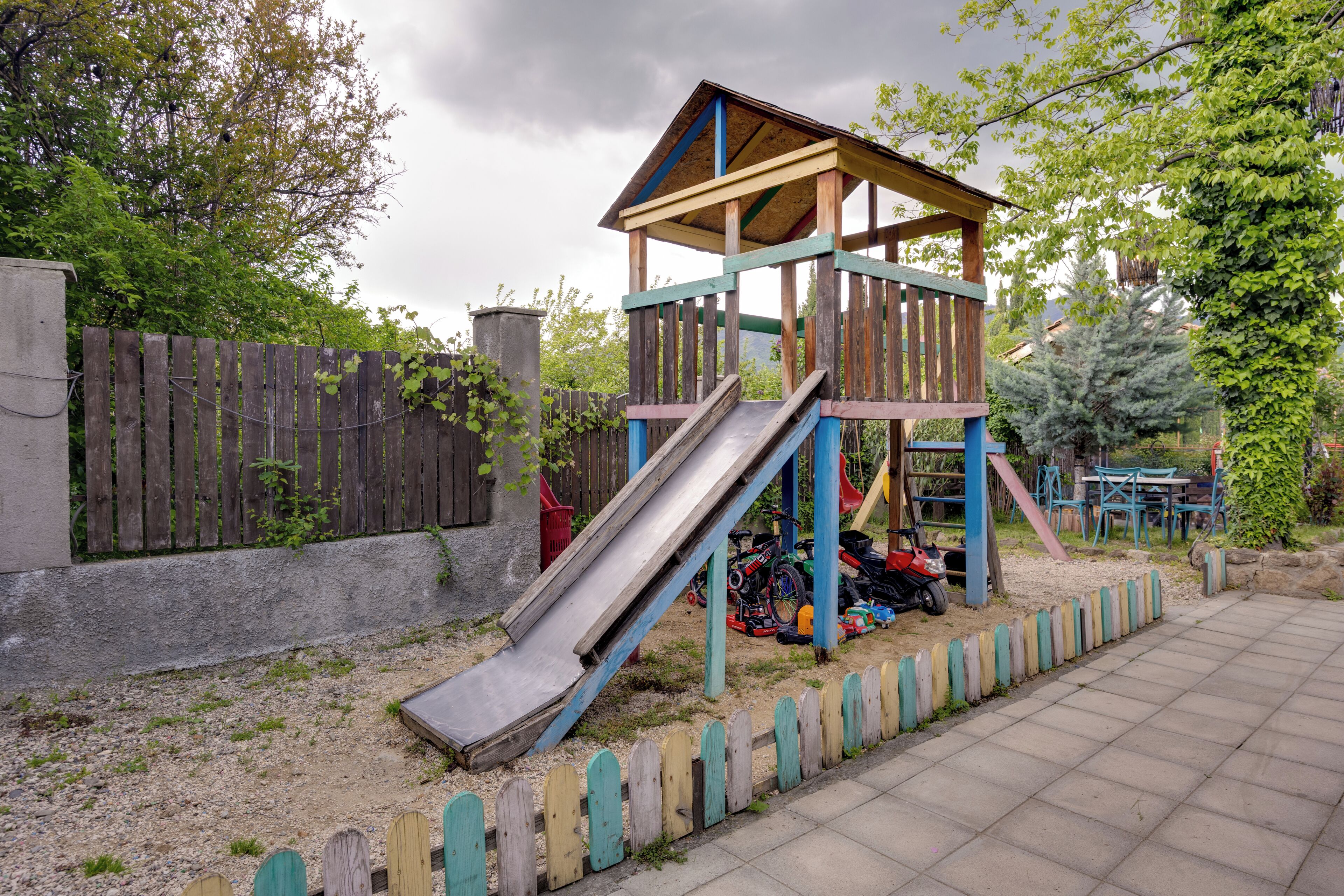 Un parque infantil con un tobogán de madera y estructuras para escalar.