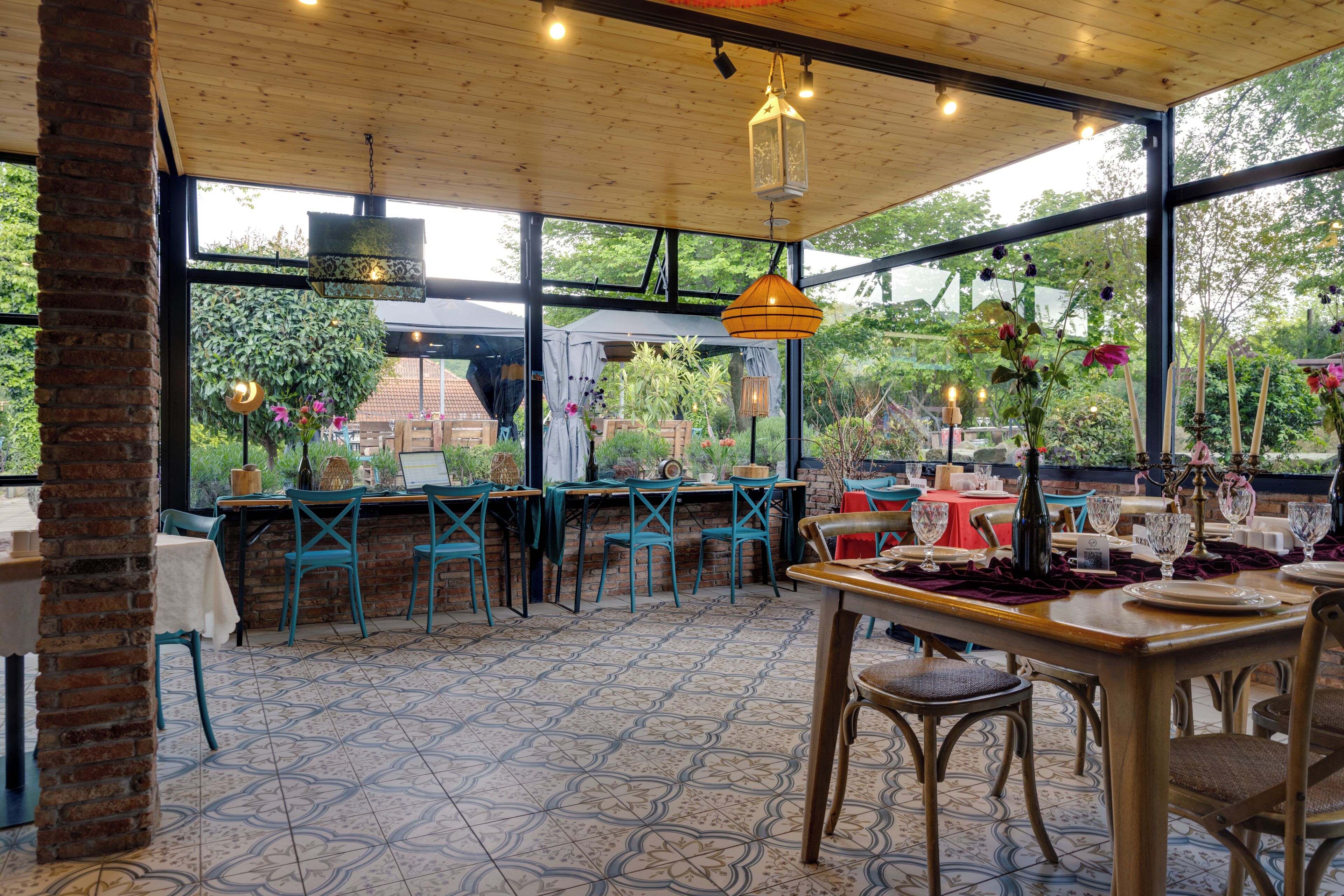 Un comedor interior con mesas dispuestas para el servicio, amplias ventanas y vistas al exterior.