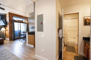 A modern interior with a dining area, kitchen, and a bathroom with a shower and toilet.