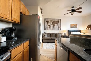 A modern kitchen with wooden cabinets, a stainless steel refrigerator, and a coffee maker.