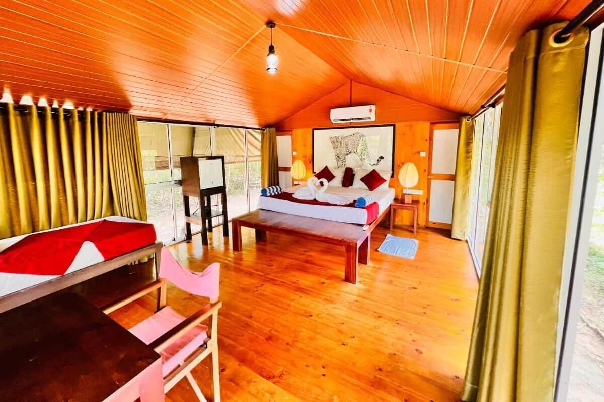 Ein gemütliches Zimmer mit Holzboden, einem Bett mit dekorativen Kissen, einem Holztisch und einem Stuhl.