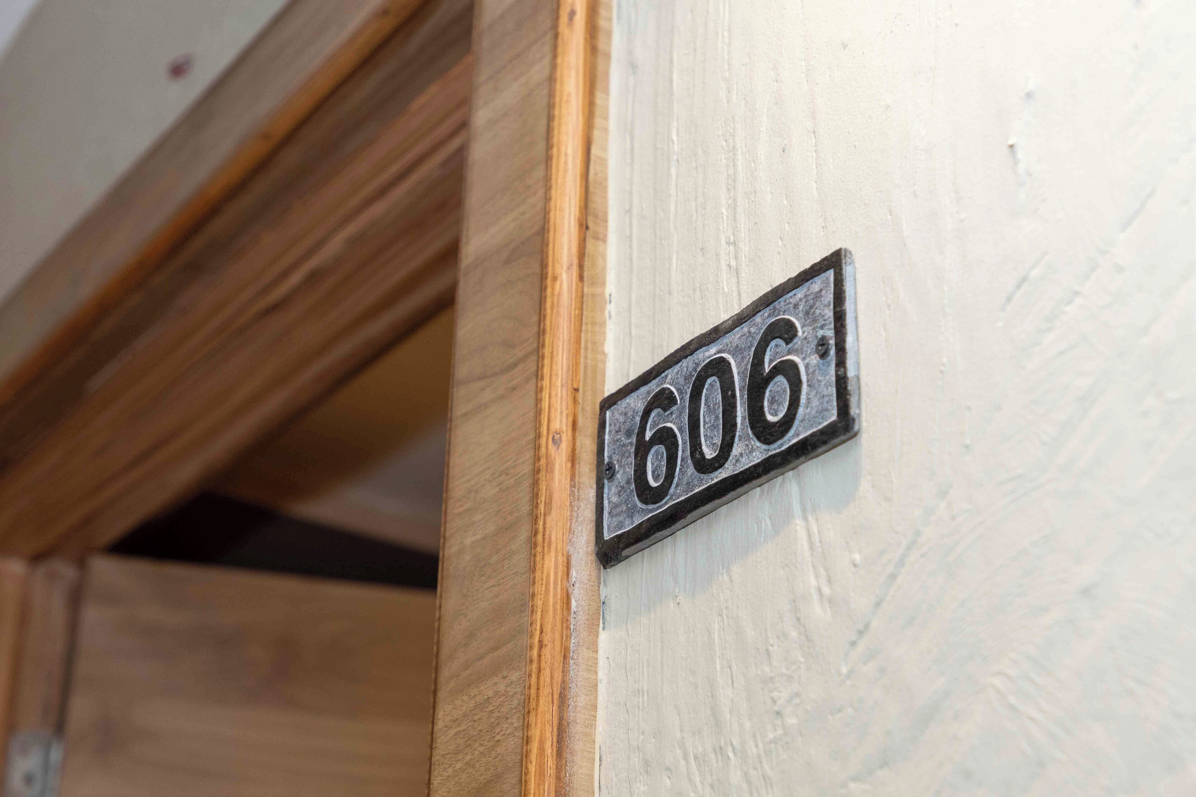 A close-up of a door with a metal plaque displaying the number 606.