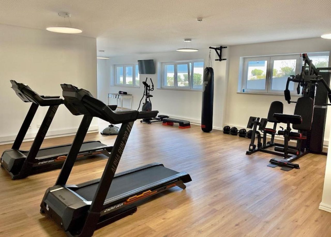 Et fitnesscenter med løbebånd, styrkemaskiner og boksebold.