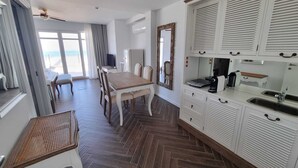 A modern kitchen with white cabinets and a herringbone wood floor. - Ocean View Apartments - Ocean View (Lourinha)