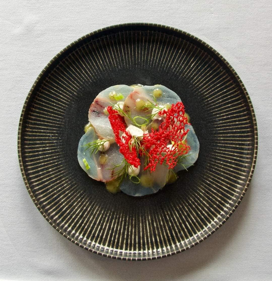 A plate with a food dish on a dark, ribbed plate.